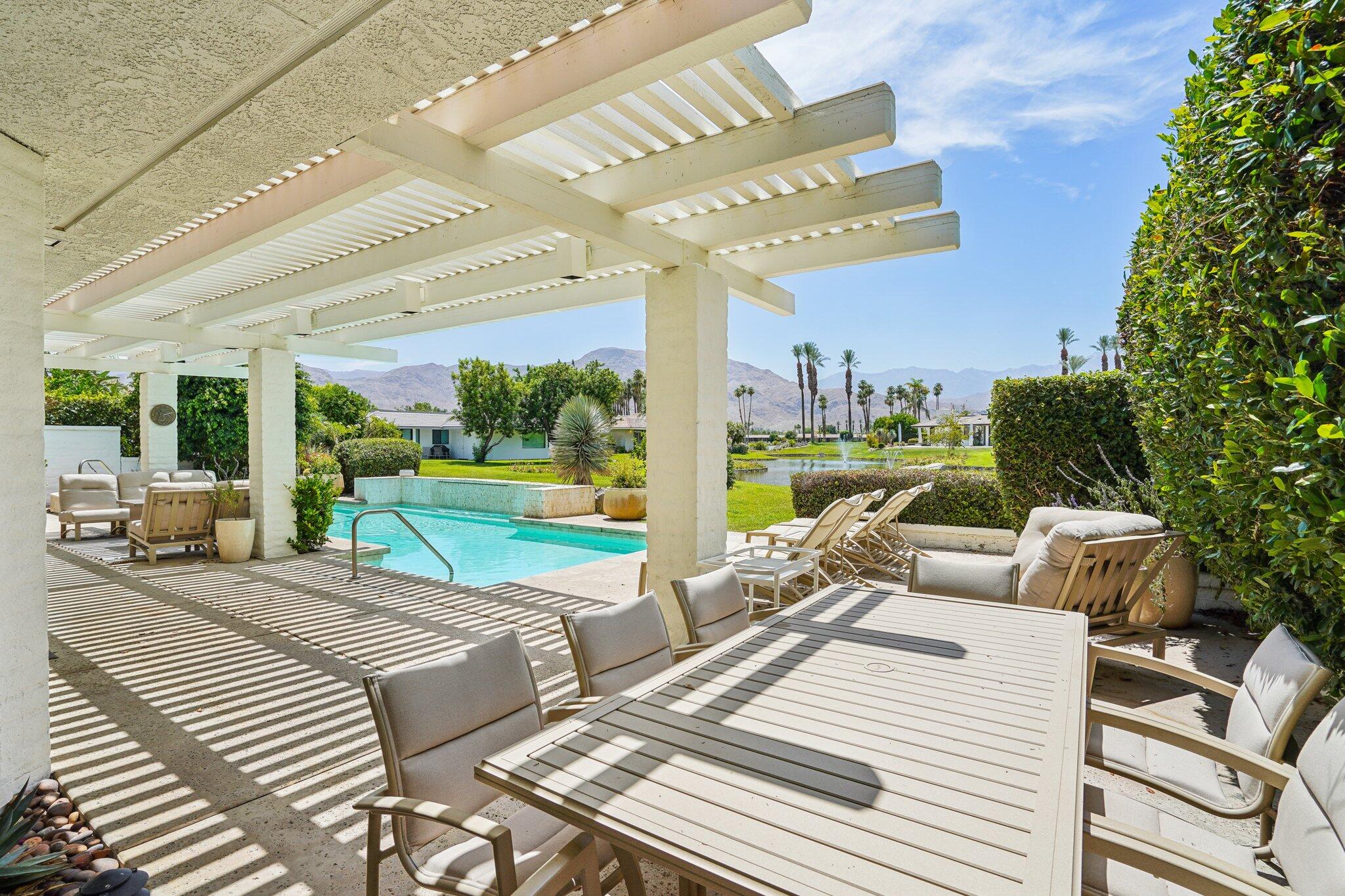 23 Park Lane Rancho Mirage, CA 92270 - Photo 20 of 57 a view of a patio with dining table and chairs with a couches near a garden