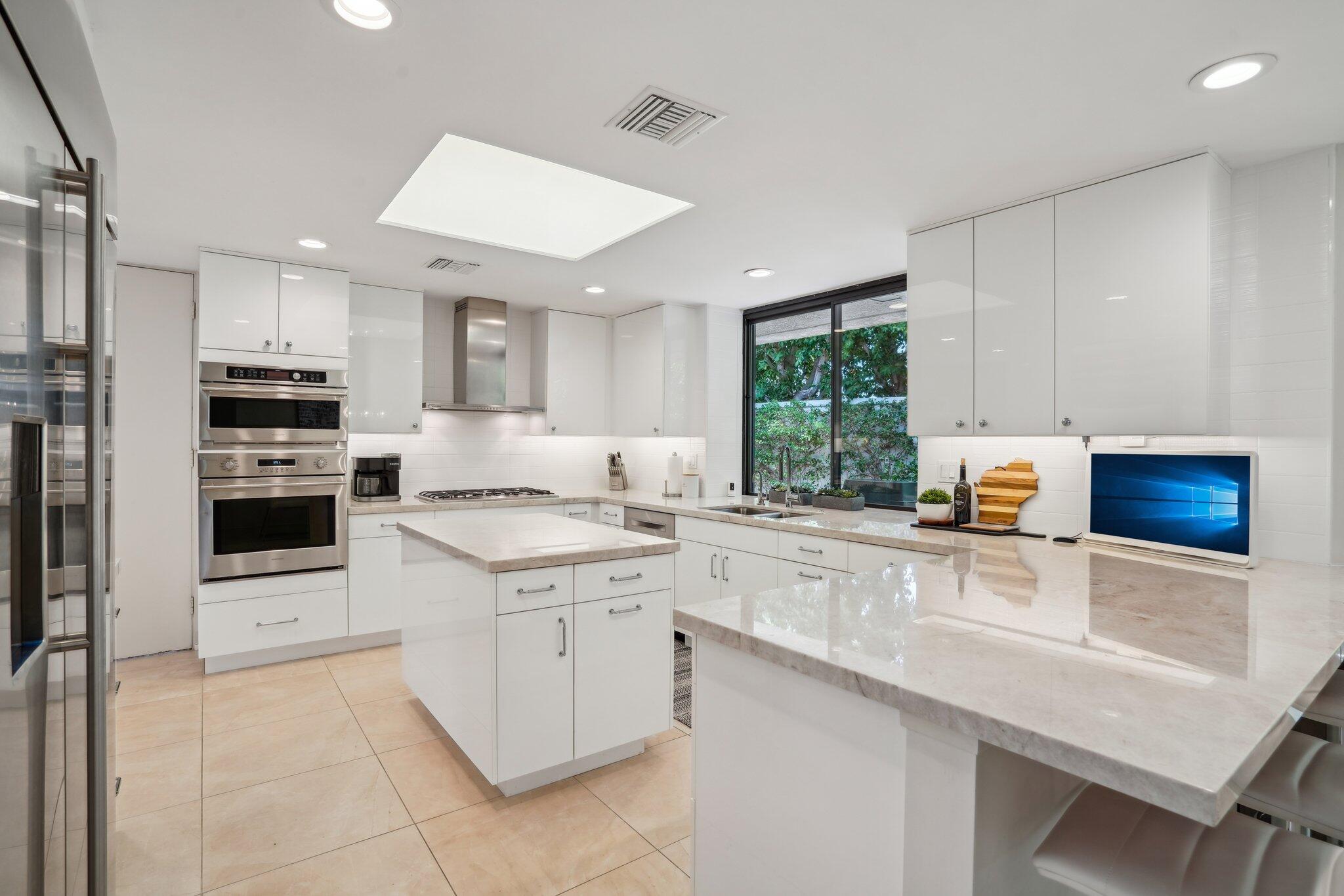 23 Park Lane Rancho Mirage, CA 92270 - Photo 27 of 57 a kitchen with stainless steel appliances a stove sink microwave and cabinets