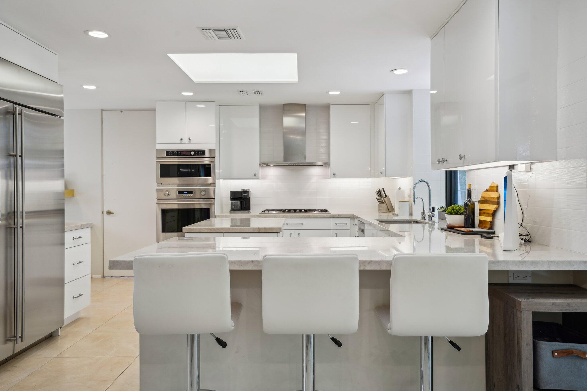 23 Park Lane Rancho Mirage, CA 92270 - Photo 28 of 57 a kitchen with stainless steel appliances granite countertop a table chairs refrigerator and sink