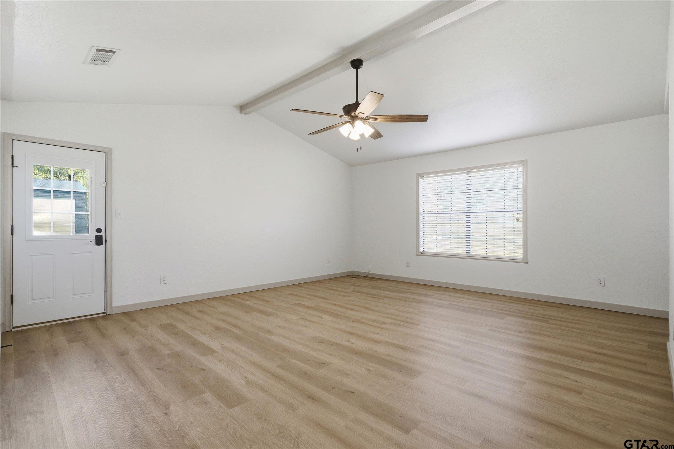 3360 Fm 1805 Van, TX 75790 - Photo 26 of 46 an empty room with wooden floor chandelier fan and windows
