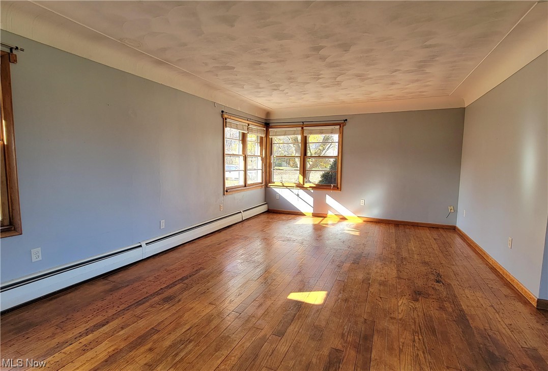405 Bryan Road Milan, OH 44846 - Photo 6 of 35 Family room with hardwood flooring and a baseboard heating unit