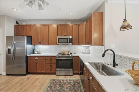 a kitchen with kitchen island granite countertop a sink stainless steel appliances and cabinets