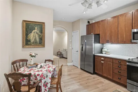a kitchen that has a lot of cabinets refrigerator and a table in it