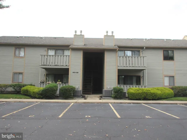 a front view of a house with yard and parking