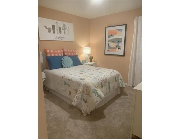 a bedroom with a bed and painting on the wall