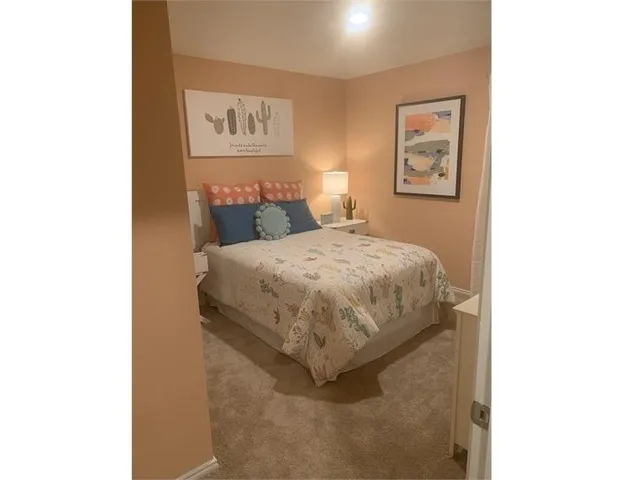 a bedroom with a bed and painting on the wall