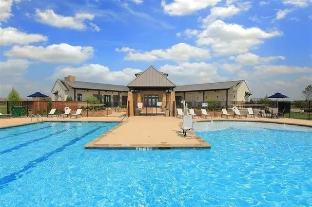 a swimming pool view with a seating space and garden view