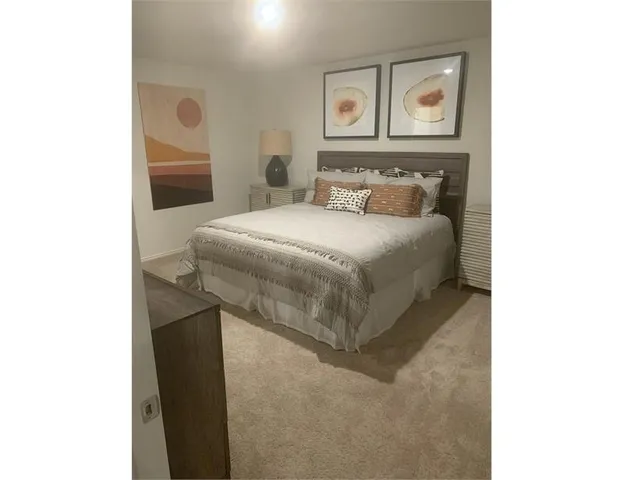 a bedroom with a bed and painting on the wall