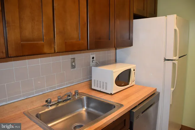 a close view of a sink and a refrigerator in a kitchen