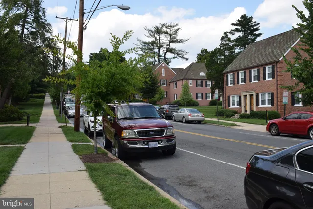 a front view of a house with a garden and trees