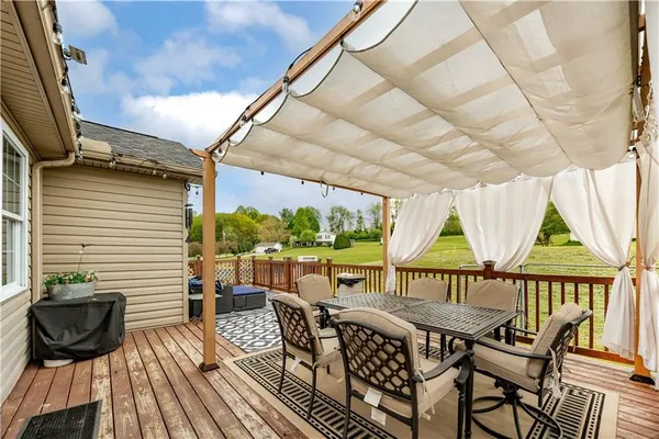 a view of a patio with table and chairs and wooden floor