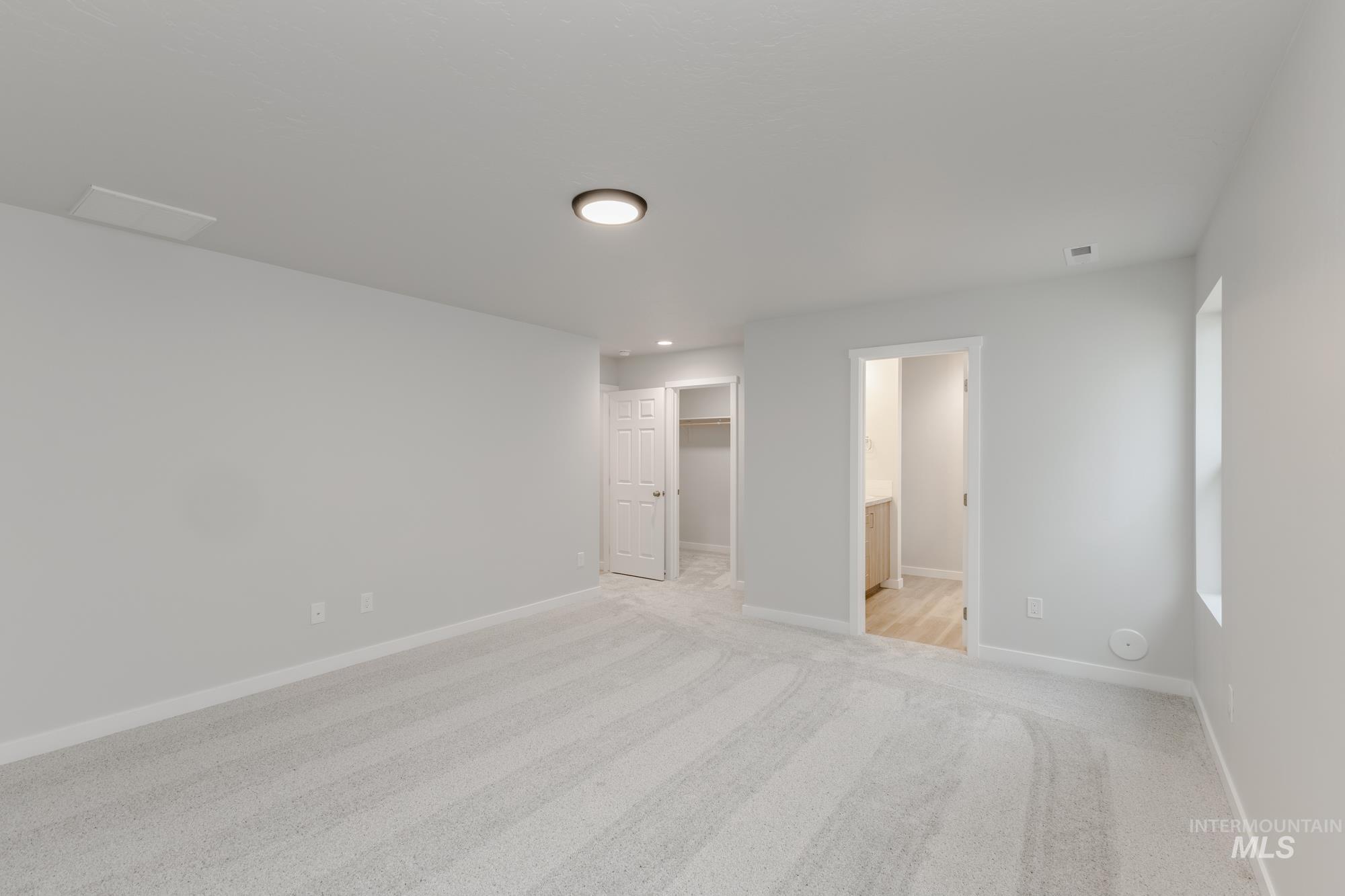 16329 Fill Avenue Caldwell, ID 83607 - Photo 16 of 18 Unfurnished bedroom with a spacious closet, light carpet, and ensuite bath