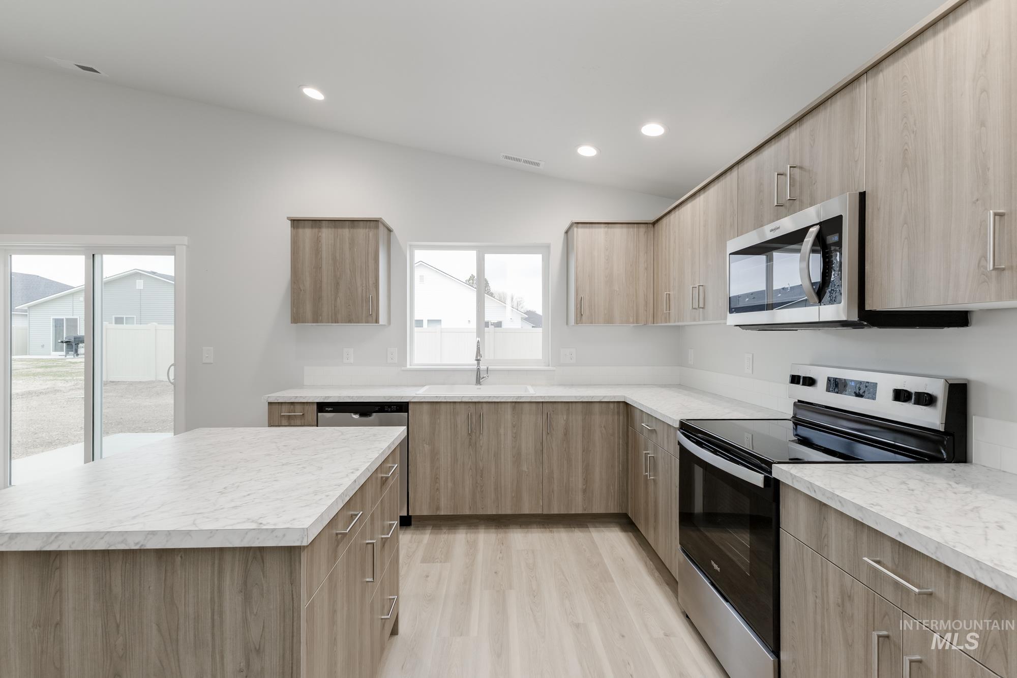 16329 Fill Avenue Caldwell, ID 83607 - Photo 5 of 18 Kitchen with stainless steel appliances, lofted ceiling, modern cabinets, light countertops, and light wood-style flooring