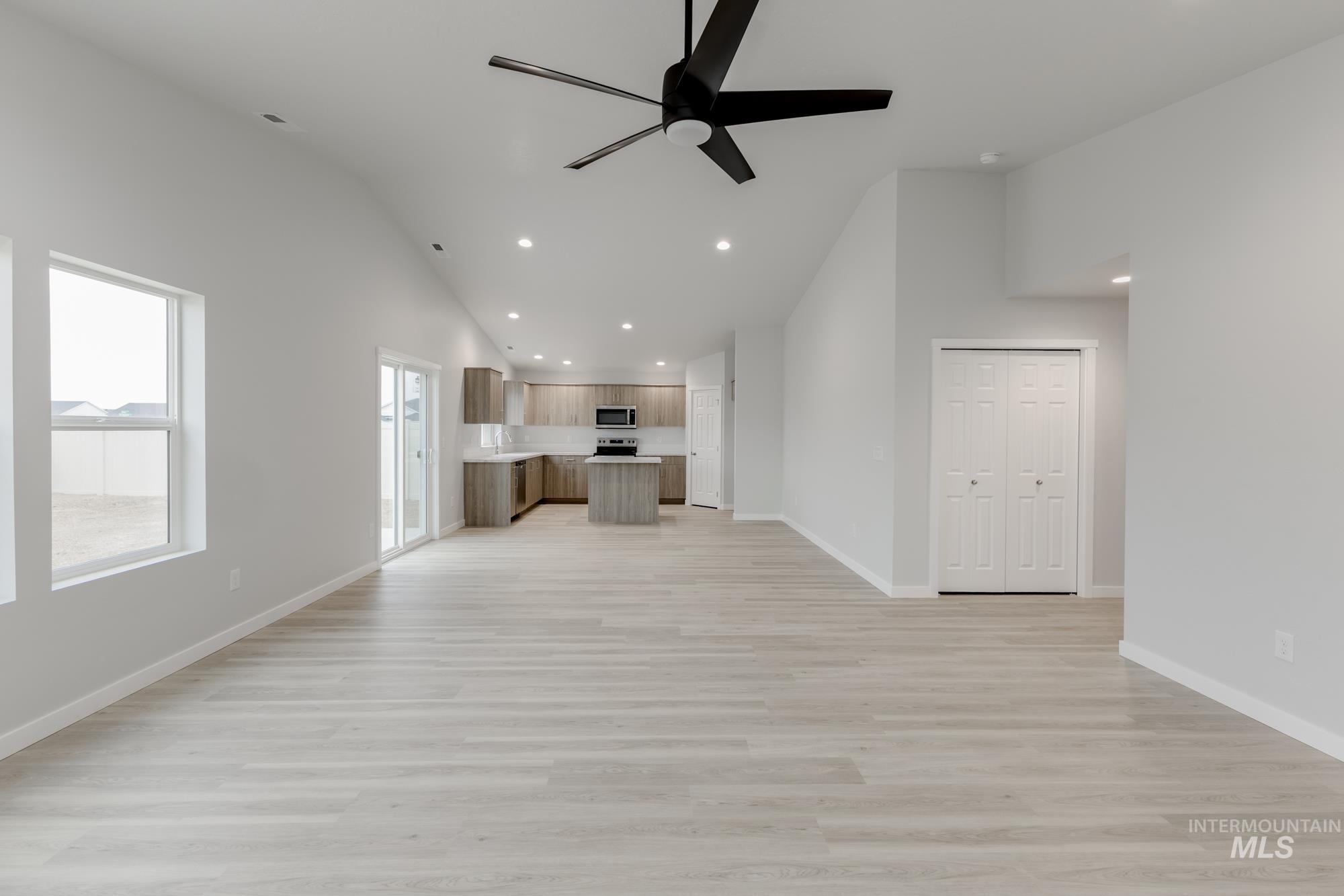 16329 Fill Avenue Caldwell, ID 83607 - Photo 9 of 18 Unfurnished living room with recessed lighting, a ceiling fan, light wood-style flooring, and high vaulted ceiling