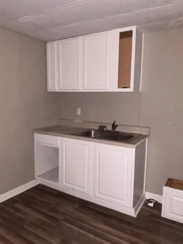 a kitchen with granite countertop wooden floors and a sink