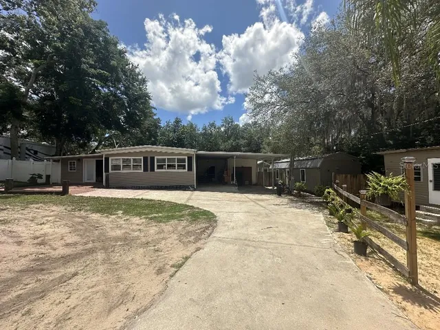 a view of a house with backyard and sitting area