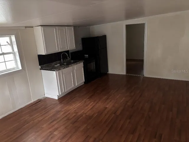 a kitchen with a refrigerator and a stove top oven