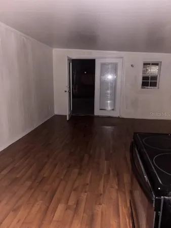 a view of an empty room with wooden floor