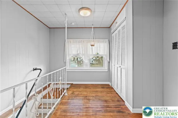 a view of a hallway with wooden floor and windows