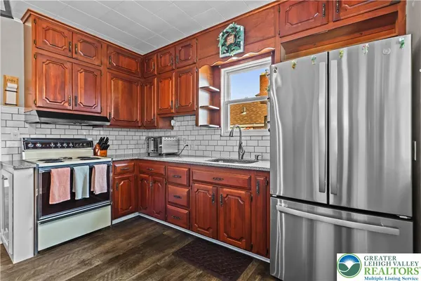 a kitchen with stainless steel appliances granite countertop a refrigerator and a stove top oven