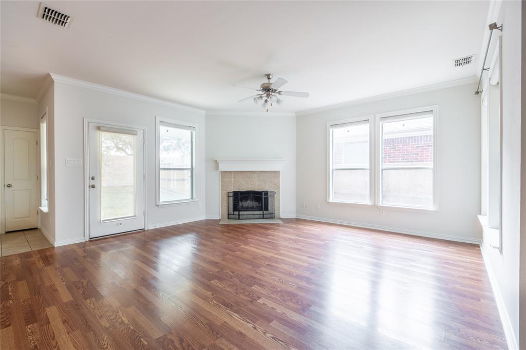 1020 Rodin Lane Carrollton, TX 75006 - Photo 2 of 25 a view of an empty room with wooden floor fireplace and a window