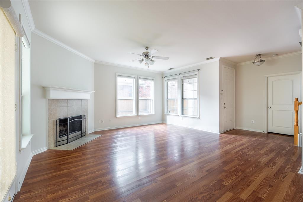1020 Rodin Lane Carrollton, TX 75006 - Photo 3 of 25 an empty room with wooden floor fireplace and windows