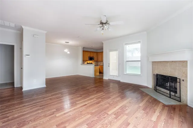 a view of empty room with wooden floor and fireplace