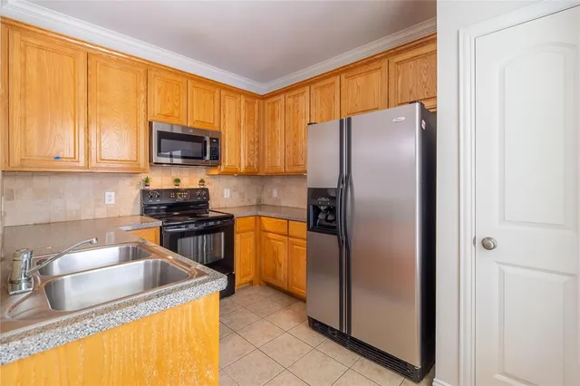 a kitchen with granite countertop a refrigerator stove and microwave