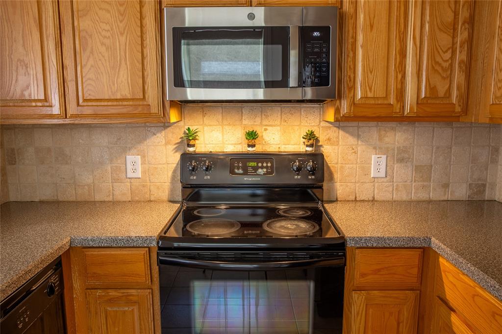1020 Rodin Lane Carrollton, TX 75006 - Photo 7 of 25 a kitchen with stainless steel appliances granite countertop a stove and a microwave oven