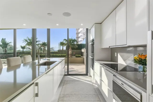 a view of a kitchen with kitchen island and stainless steel appliances