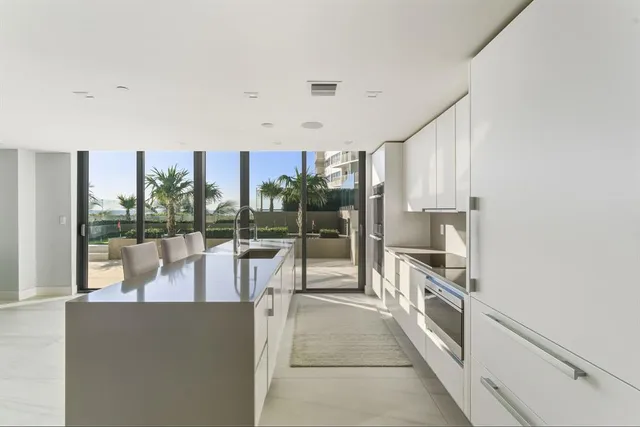 a room with a large window and kitchen view
