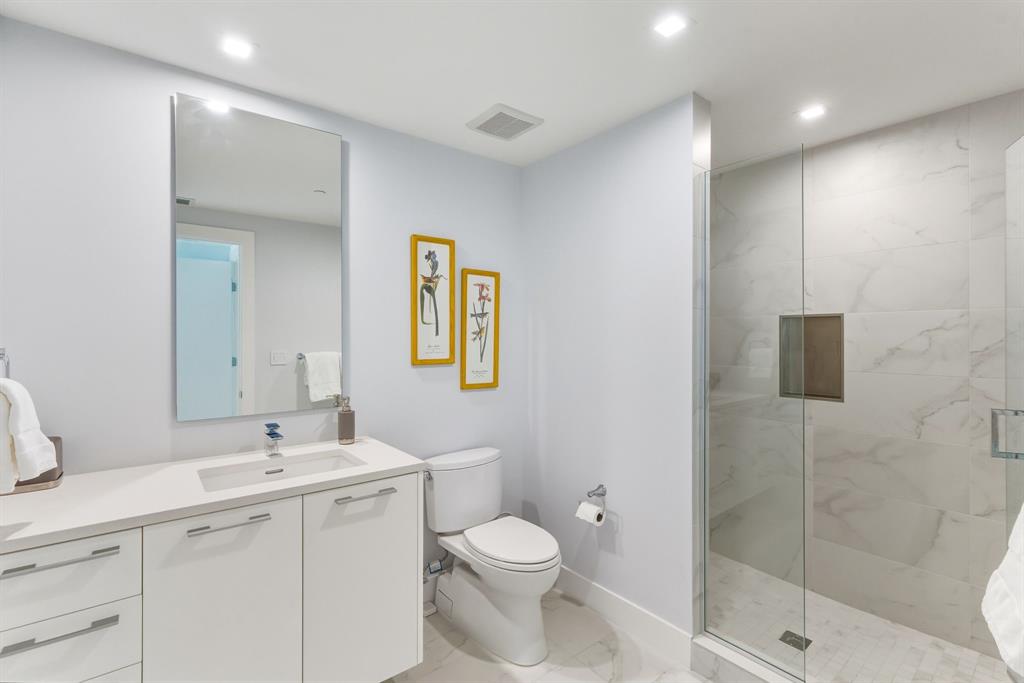 730 North Ocean Boulevard, Unit 404 Pompano Beach, FL 33062 - Photo 25 of 47 a bathroom with a toilet a sink a mirror and a shower