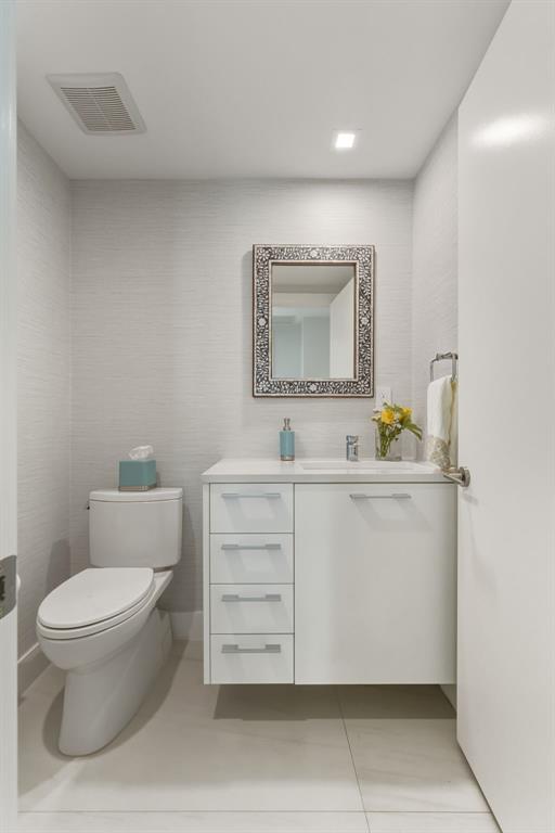 730 North Ocean Boulevard, Unit 404 Pompano Beach, FL 33062 - Photo 26 of 47 a bathroom with a toilet a sink and mirror