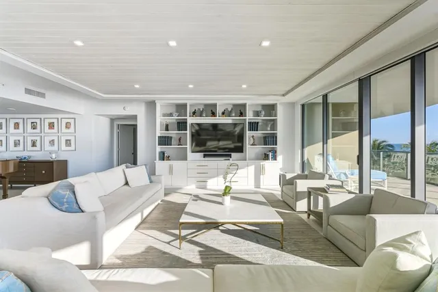 a living room with furniture large window and flat screen tv