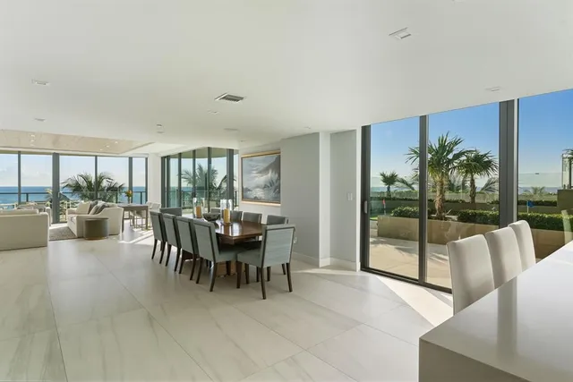 a dining room with furniture and a floor to ceiling window