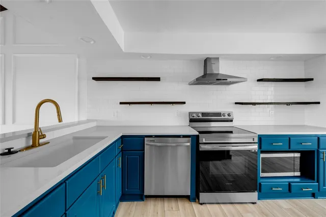 a kitchen with stainless steel appliances granite countertop a sink and a stove