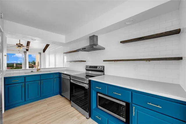 a kitchen with stainless steel appliances granite countertop a sink dishwasher stove and oven with wooden floor
