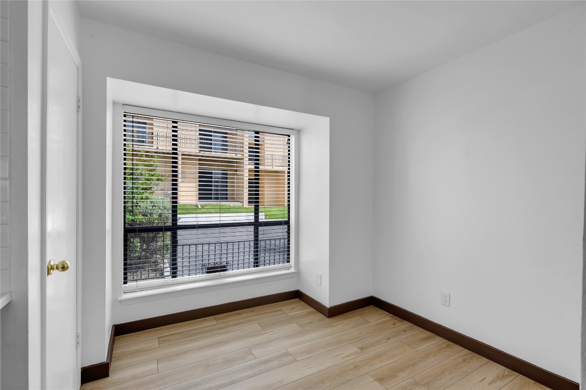 402 Hi Stirrup, Unit E2 Horseshoe Bay, TX 78657 - Photo 17 of 39 a view of an empty room with wooden floor and a window