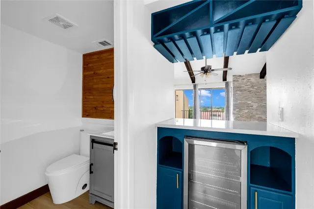 a view of a hallway with a chair and potted plant next to a window
