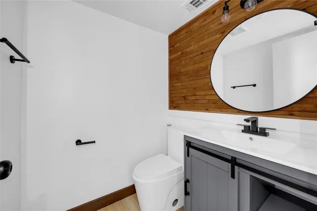 a bathroom with a sink mirror vanity and toilet