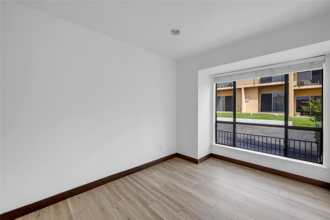 402 Hi Stirrup, Unit E2 Horseshoe Bay, TX 78657 - Photo 21 of 39 an empty room with wooden floor and windows