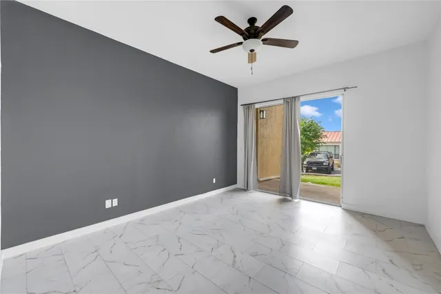 an empty room with fan and windows