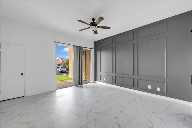 a view of an empty room with a window and cabinet
