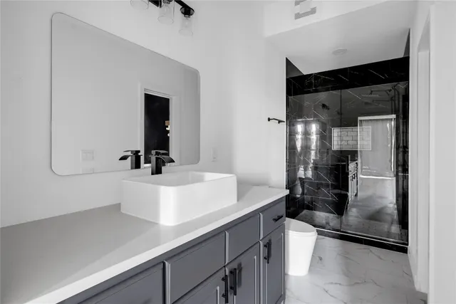 a bathroom with a sink a toilet and shower