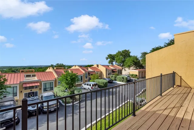 a balcony with wooden floor and city view