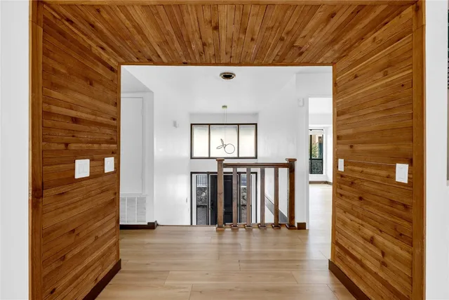 a view of a hallway with wooden floor and staircase