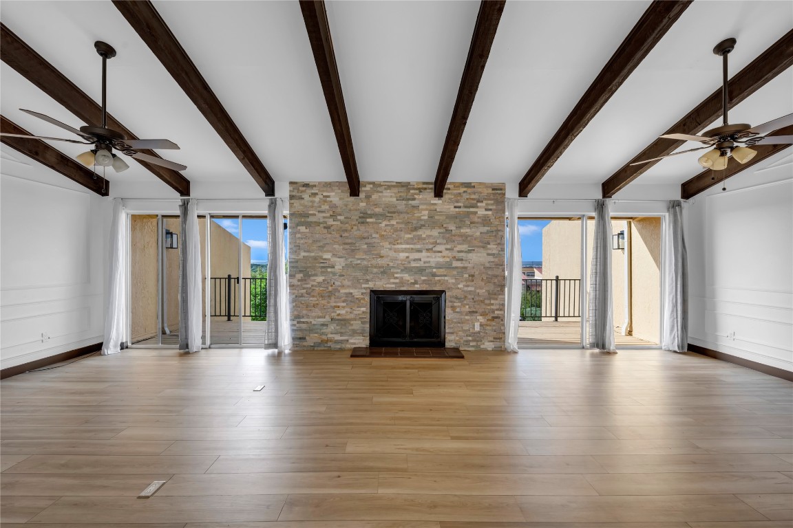 402 Hi Stirrup, Unit E2 Horseshoe Bay, TX 78657 - Photo 9 of 39 a view of an empty room with wooden floor and fireplace