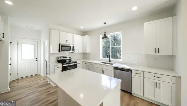 a kitchen with white cabinets and stainless steel appliances