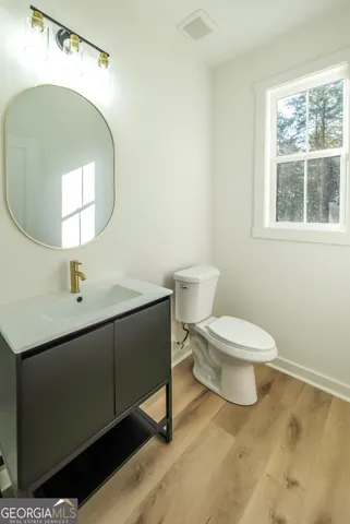 a bathroom with a toilet sink and mirror