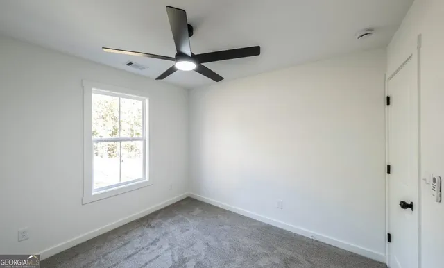 a view of empty room with ceiling fan